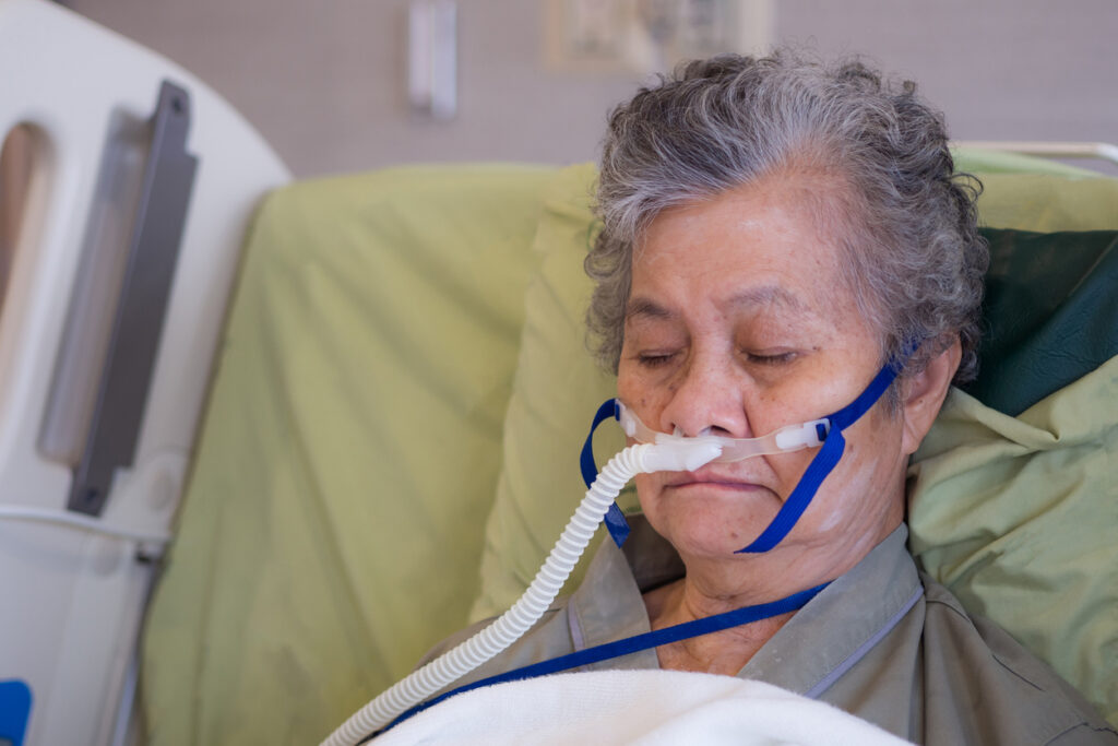 Close-up of elderly female patient with lung disease, receiving oxygen therapy in hospital during ventilator treatment